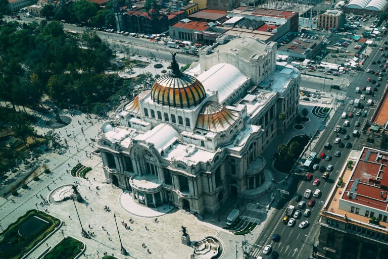 Aerial view showcasing the iconic Palacio de Bellas Artes amidst the bustling streets of Mexico City.