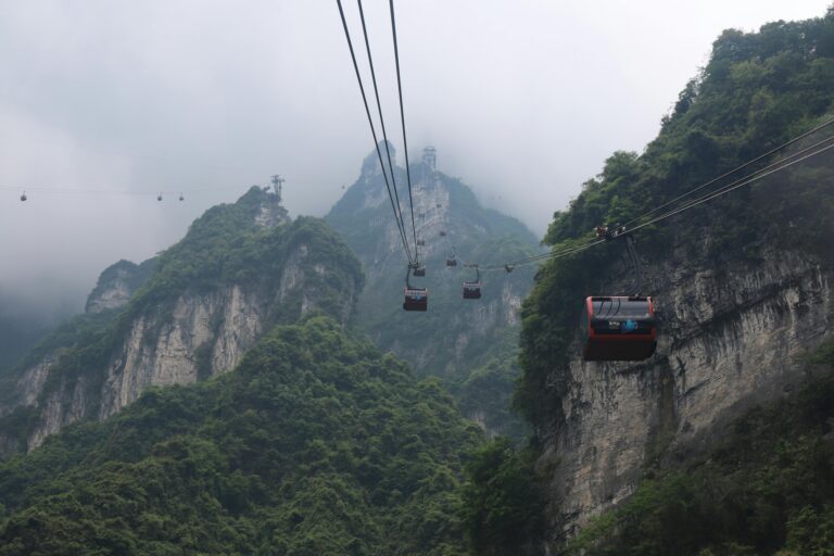 Scenic view of cable cars ascending Tianmen Mountain in Zhangjiajie, China, shrouded in mist.