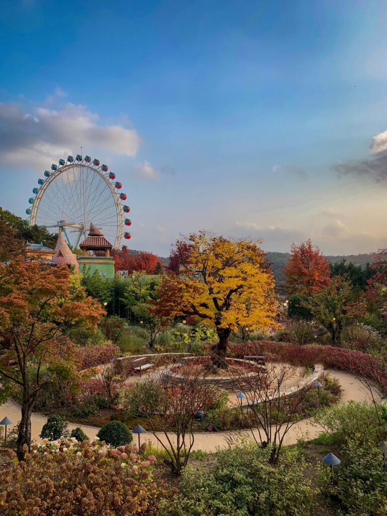 Vibrant autumn landscape featuring a Ferris wheel amidst colorful foliage, capturing a joyful mood.