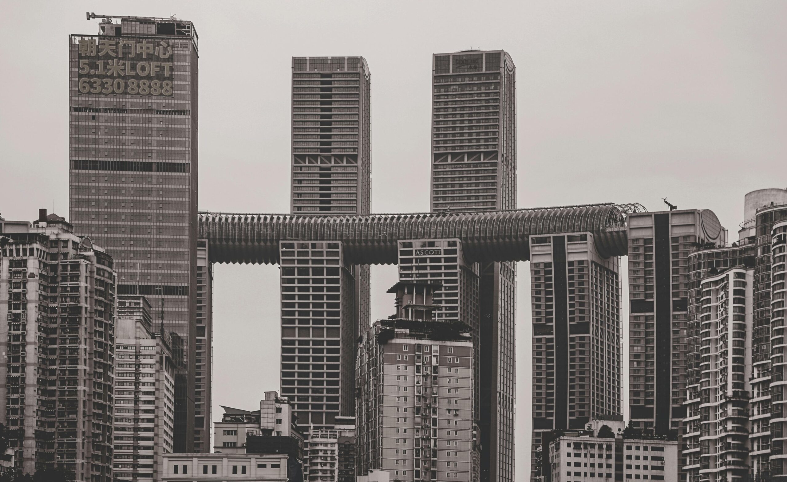 Black and white image of towering skyscrapers showcasing modern architecture in a bustling cityscape.