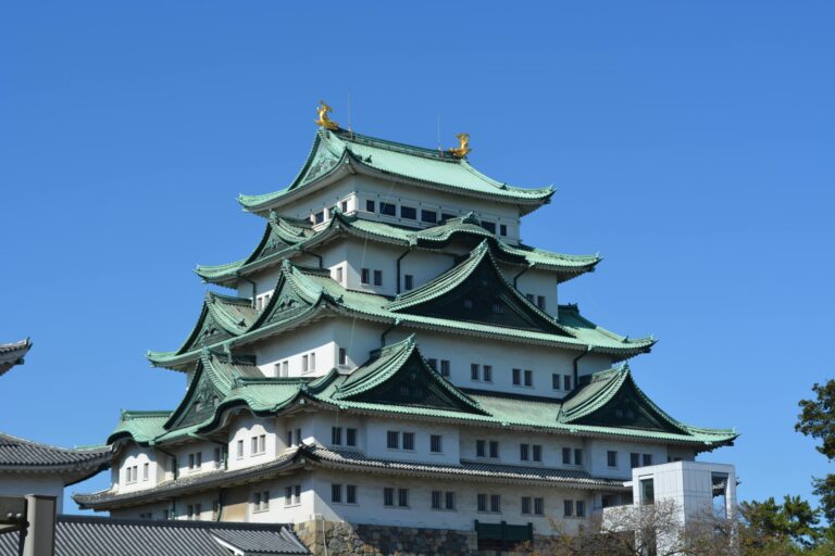 Captivating view of Nagoya Castle's traditional architecture under a clear blue sky.