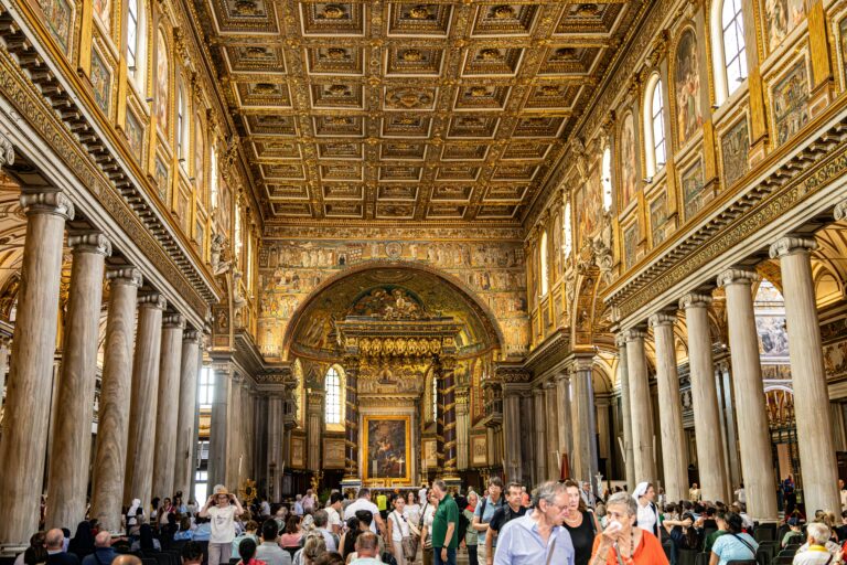 The opulent interior of Santa Maria Maggiore, capturing ornate details and visitors.