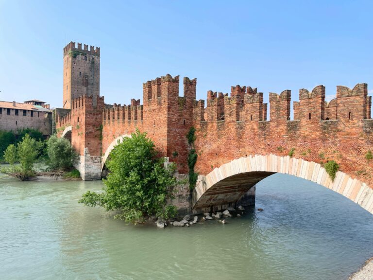 Historic Castelvecchio Bridge over the Adige River in Verona, Italy, on a sunny day.