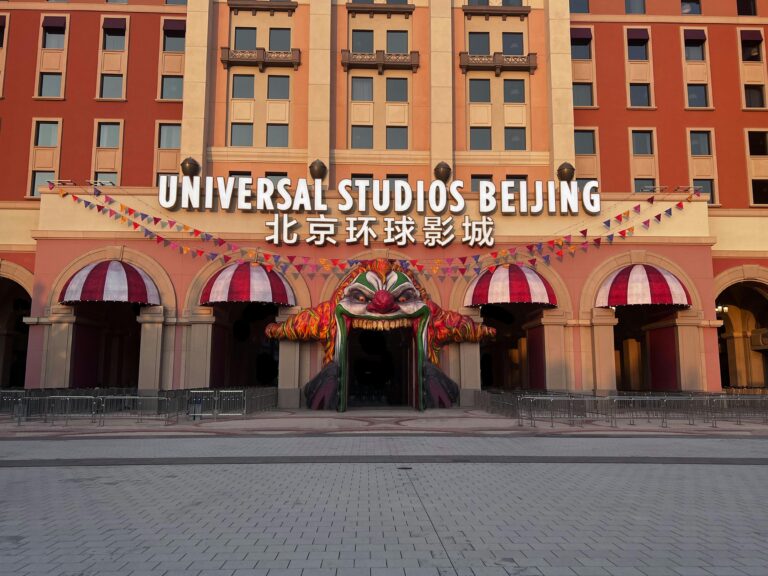 Entrance to Universal Studios Beijing with vibrant clown-themed decor and festive flags.
