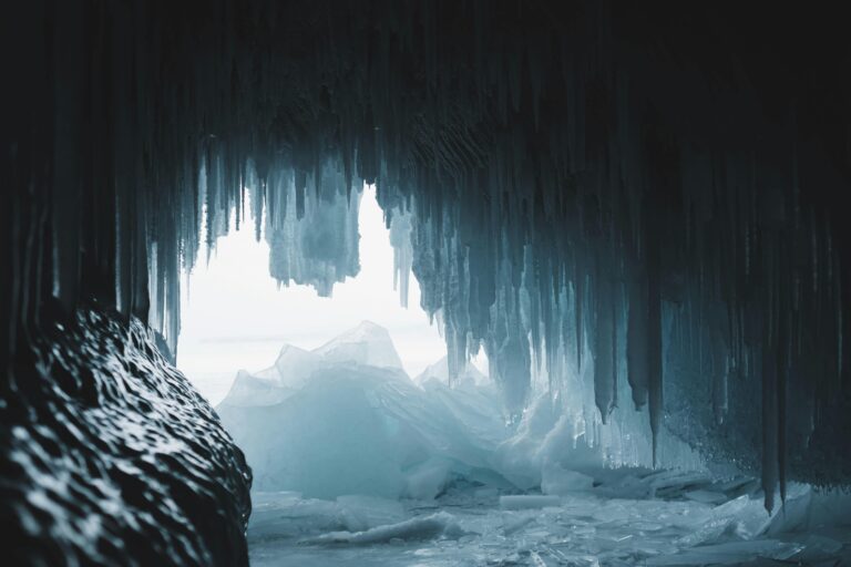 Explore the majestic beauty of a frozen cave filled with sharp icicles. Perfect for winter themes.