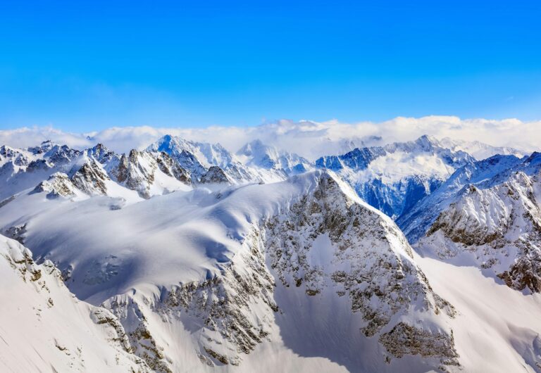 Breathtaking view of the snow-covered peaks in the Swiss Alps under a clear blue sky.